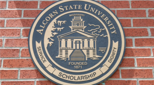 Alcorn State University seal on a brick wall. Seal of Alcorn State University with the words, "Service", "Scholarship", and "Dignity" inscribed underneath on a brick wall.