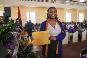 President's list scholar holding certificate.