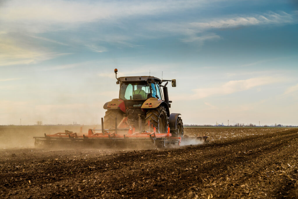 Tractor cultivating field at spring Socially Disadvantaged Farmers and Ranchers Policy Research Center