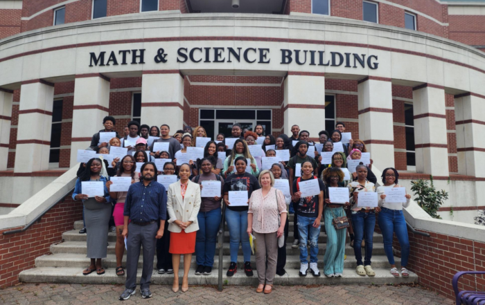 Biology students and faculty hold certificates in front of the Math & Science Building after completing AI and machine learning training through NSF grant partnership