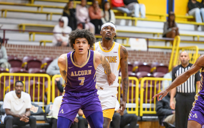 Alcorn State University men's basketball player Nick Woodard, wearing jersey No. 7 in purple and gold, battles for position against a Bethune-Cookman defender during a SWAC game.