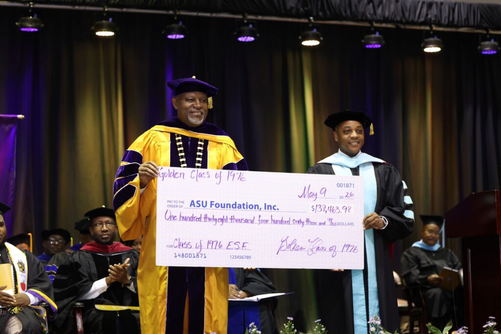 Alcorn State University President Tracy M. Cook and Dr. Marcus Ward, senior vice president for institutional advancement and executive director of the ASU Foundation, hold a ceremonial check for $138,463.98 presented by the Golden Class of 1976 to the ASU Foundation during the 2026 Spring Commencement ceremony in Lorman, Mississippi.